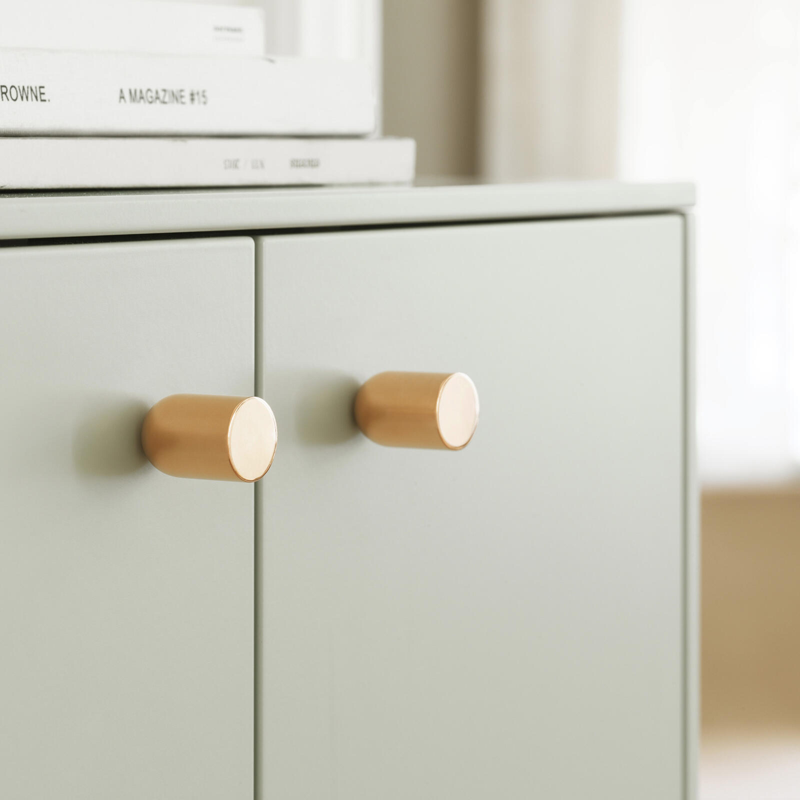 Knob in brass on a pale green front from Superfront