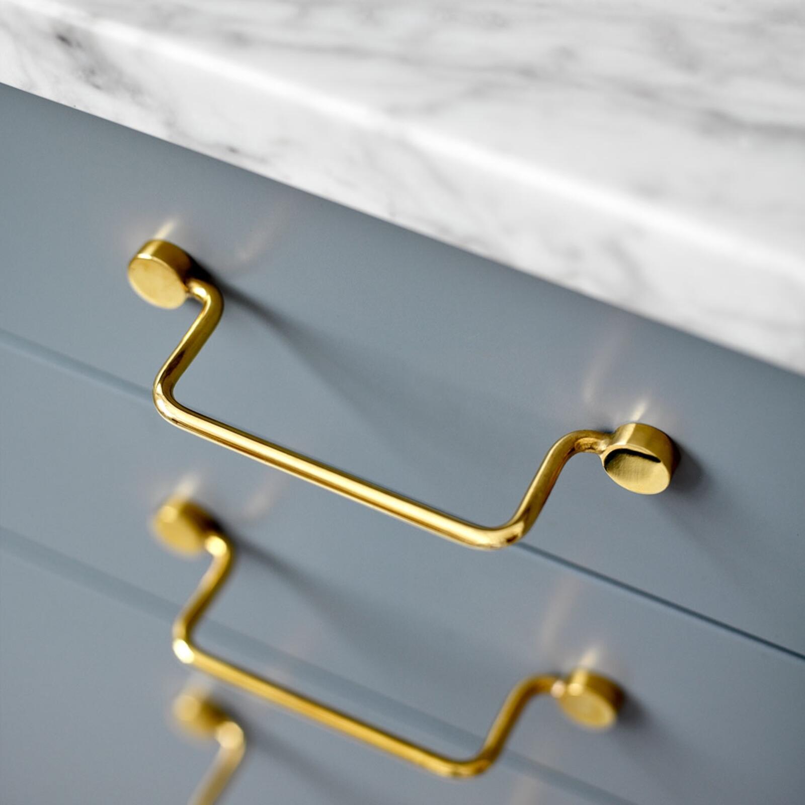 Classic handles in brass from Superfront, mounted on grey kitchen drawers