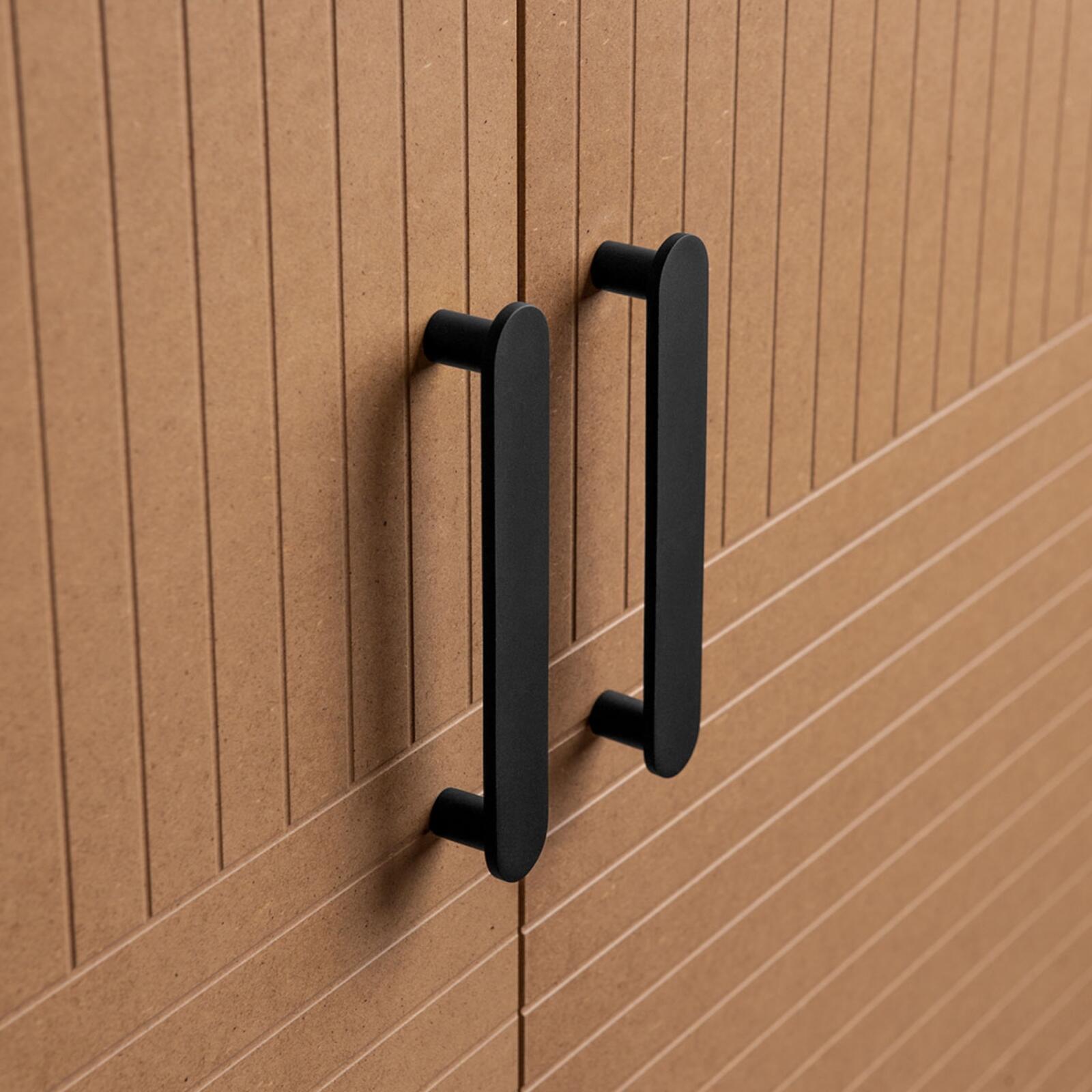 Elongated, matte black handles on wardrobe fronts from Superfront