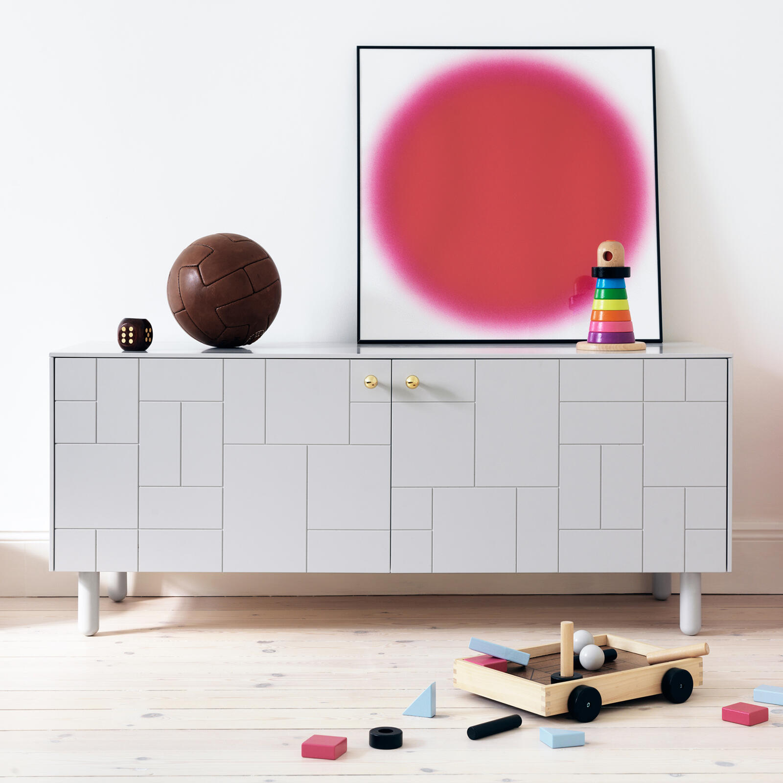 Sideboard in children's room with cube patterned fronts and minimalist furniture leg in grey
